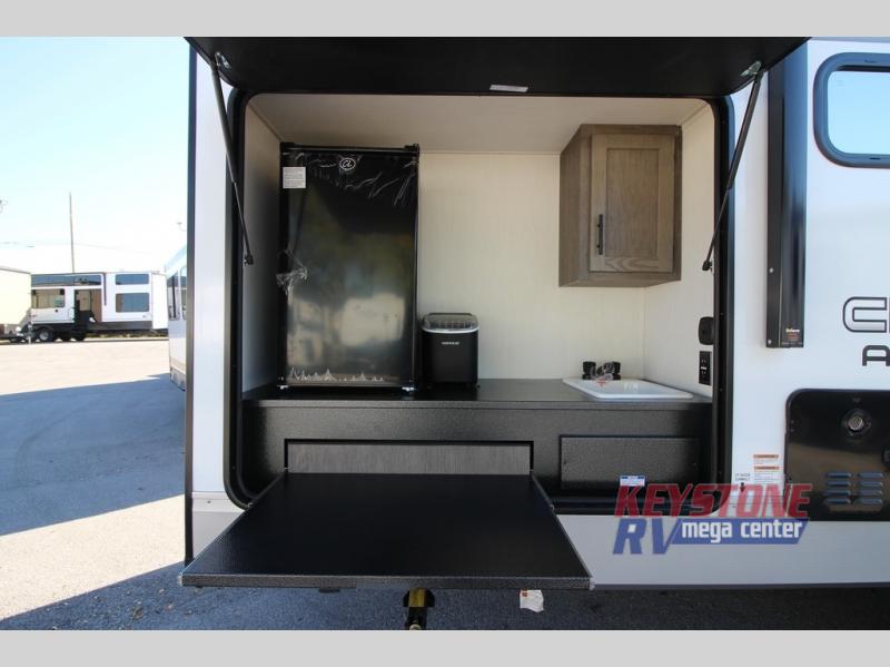 Forest River RV Cherokee Alpha Wolf 25RB outdoor kitchen with a counter, cabinet, sink, ice maker, and fridge